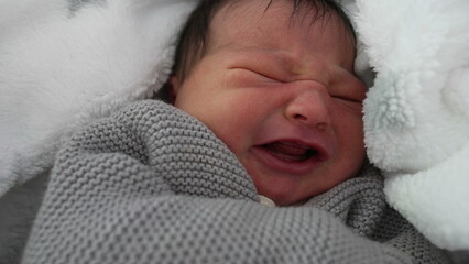 Newborn baby bundled in a cozy blanket with a slight frown, showing signs of discomfort, capturing a moment of early life emotions, wrapped warmly and nestled securely-SD 480p