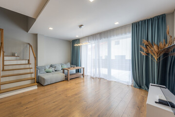 Modern Living Room With Staircase, Wooden Flooring, Natural Light, TV Screen