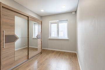 Minimalist Home Empty Room with Wooden Mirror Closet and Natural Light