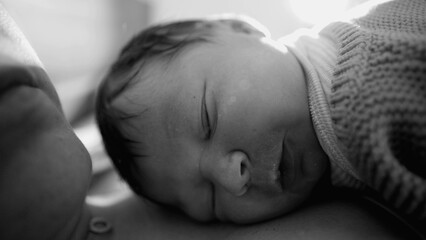 Newborn baby nestled against mother’s chest, peacefully asleep with a calm expression, capturing...