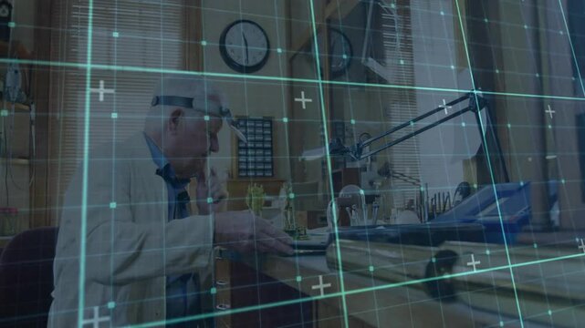 Senior watchmaker using loupe examining components at bench showing glowing digital grid