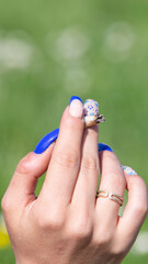 Woman hand holding marijuana joint with blurred green background