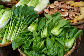 Obraz premium High angle view of fresh Asian vegetables including bok choy, napa cabbage, and shiitake mushrooms displayed in traditional woven baskets at a market stall