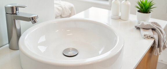 Immaculate ceramic sink in cozy bathroom during daylight, serene cleanliness
