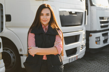 Portrait of a beautiful woman truck driver standing in the parking lot