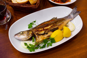Baked seabass fish called in turkey Levrek with lemon and herbs.