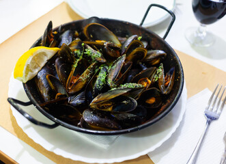 Seafood. Delicious steamed mussels with lemon in frying pan