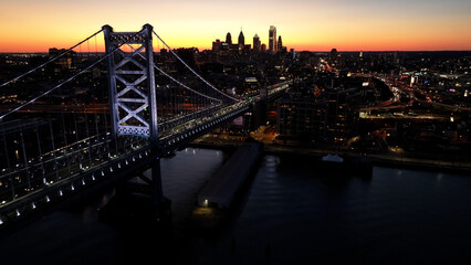 Sunset In Philadelphia Skyline At Philadelphia In Pennsylvania United States. Illuminated Downtown. Sunset City Landscape. Philadelphia At Pennsylvania United States. Ben Franklin  Bridge. 