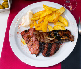 On plate was juicy slice of grilled beef with delicious French fries, and sprinkled with red smoked paprika
