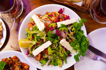 Healthy organic turkish choban salad with cheese, tomato, cucumber, herbs and lemon