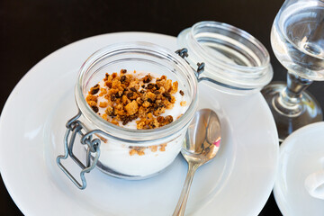 Tiramisu traditional italian dessert in glass jar, garnished with cookies