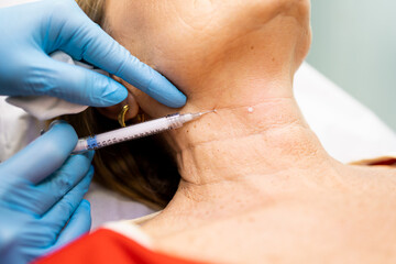 The woman undergoes a treatment to smooth wrinkles and folds and stimulate collagen production in...