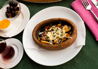 Traditional Turkish mushroom saute with grated cheese served in earthenware dish. Authentic cuisine..