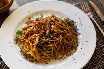 Popular Chinese dish chow mein of fried noodles with beef pieces and vegetables in spicy sauce