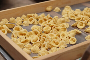 Orecchiette, a type of Italian pasta. Demonstration of the famous Apulian orecchiette common in Italy. Varieties of fresh pasta. Italian pasta in the shape of small ears. Handmade orecchiette pasta