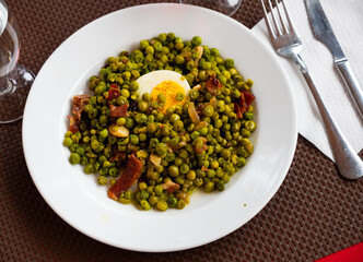 Delicious dish of green peas with ham. Decorated with boiled egg, cut in half..
