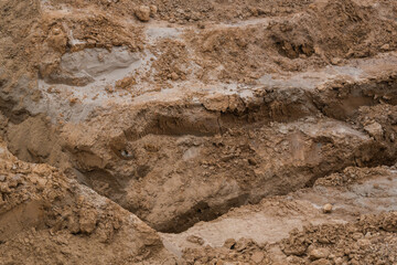 Brown and ochre soil layers exposed by excavation, revealing the diverse composition of minerals...