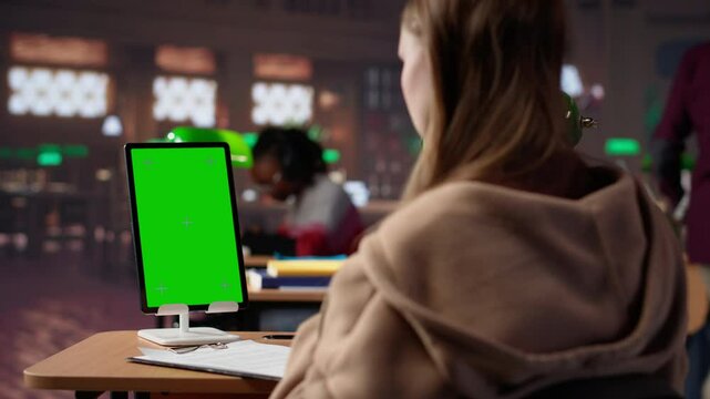 Young female student studies for upcoming exams with copy space at the library, collecting academic information to use as citations for her college paper. Bachelor degree research. Camera A.