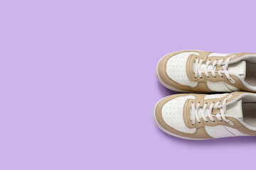 Stylish sneakers on purple background