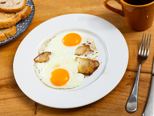 Appetizing breakfast with scrambled eggs and juicy bacon