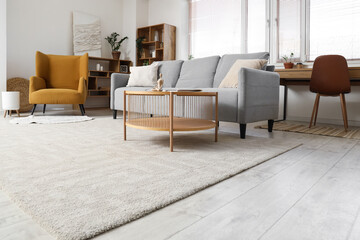 Interior of living room with grey sofa, armchair and window