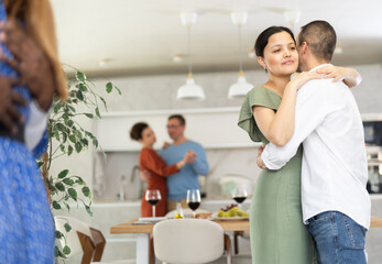 Men and women of different nationalities having fun dancing slow dance at a house party