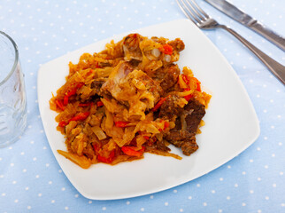 Traditional russian cuisine, stewed cabbage with chopped pork meat at a cafe