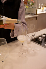 Tasting of brut champagne sparkling wine produced by traditional method in underground caves close up, pouring of wine