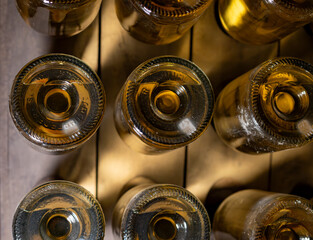 Bottles on racks in deep and long undergrounds caves, making champagne sparkling wine from...