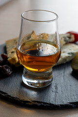 Whiskey and cheese pairing, tasting whisky glass and plate with sliced blue stilton and blue shropshire cheeses, Great Britain food and drink
