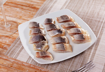 Pieces of raw pickled fish herring served on plate
