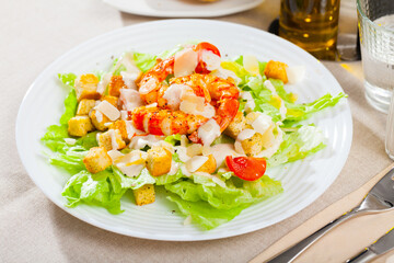Caesar salad with grilled chicken on a white plate. High quality photo