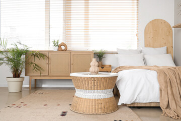 Bed, coffee table and chest of drawers in interior of bedroom