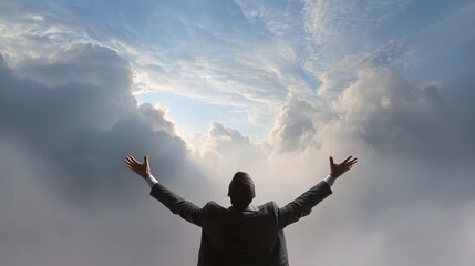 Businessman Reaching for the Sky with Open Arms Against Clouds