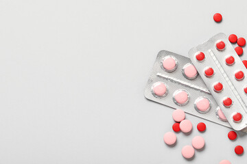 Different pills in blister packs on grey background