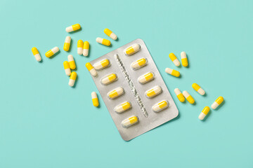 Hard capsules in blister pack on turquoise background
