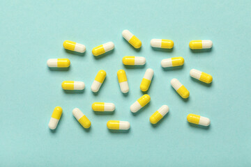 Many hard capsules on turquoise background