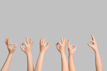 Female hands showing OK on light background