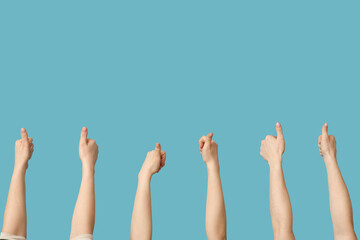 Female hands showing thumbs-up on blue background
