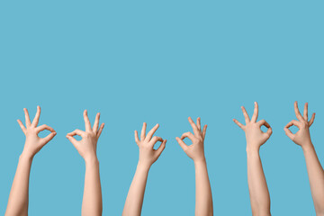 Female hands showing OK on blue background