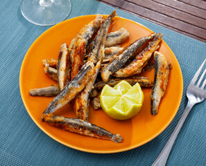 Fried anchovies served with slice of lemon, seafood appetizer