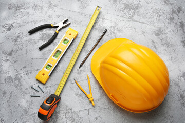 Hardhat and construction tools on white grunge background