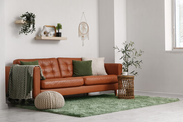 Modern interior on living room with brown leather sofa and soft pouf