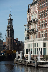 Naklejka premium Canal View with Historical Tower and Riverside Café