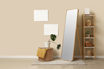 Interior of room with shelving unit and floor mirror near beige wall