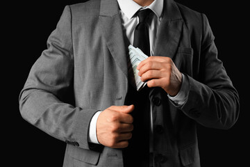 Businessman with money on black  background, closeup