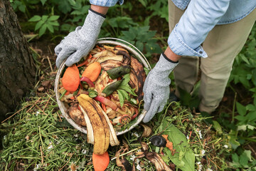 Compost heap pile with bio waste. Farmer with vegetables and fruits food scraps in bucket for compost. Zero waste, composting concept © Viktor Iden