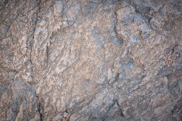 Close-up view of rough grey stone surface forming a natural background texture, ideal for design projects