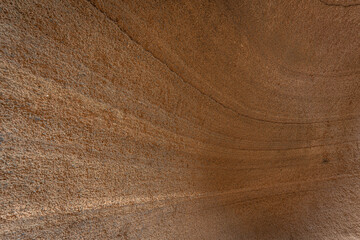 Close-up view of sandstone formations revealing smooth curves and warm brown tones, creating a natural abstract background
