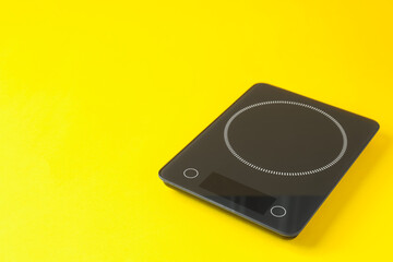 Fototapeta premium Electronic kitchen scale on yellow background. Space for text